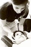 Virginie Socrate, chiropraticien, effectue un travail crânien chez un enfant souffrant d'otites à répétition.